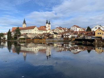 Reflection of buildings in city against sky