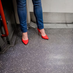 Low section of people standing in red shoes