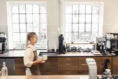 Blurred motion of barista walking at cafe