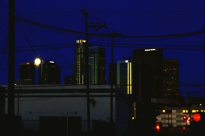 Illuminated city against sky at dusk