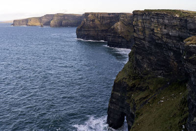 Rock formations by sea against sky