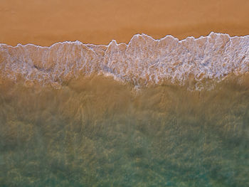 Close-up of water flowing over sea during winter