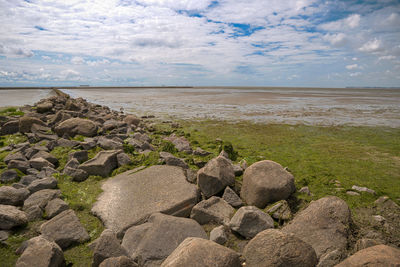 Rocks on beach against sky