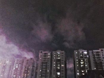 Illuminated buildings against sky at night