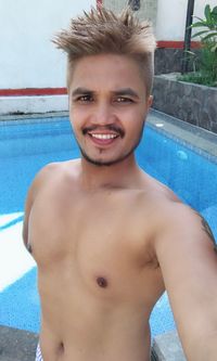 Portrait of young man standing in swimming pool