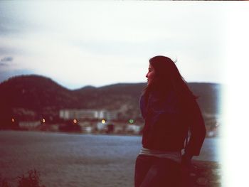 Woman looking at river against sky