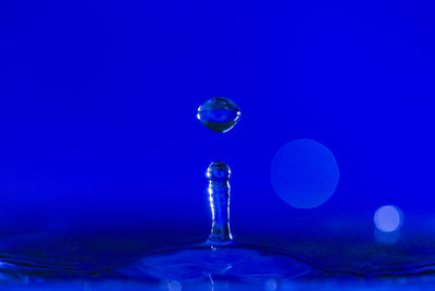 Close-up of water drop against blue background