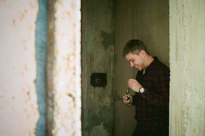 Smiling young man holding electronic cigarette