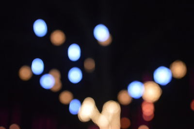 Close-up of hand against illuminated blurred background