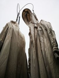 Low angle view of statue hanging against sky