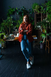 Portrait of young woman sitting on footpath