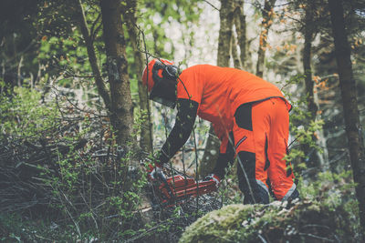 Man holding a chainsaw and cut trees. lumberjack at work . gardener working outdoor in the forest.