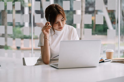 Woman using mobile phone while sitting on table