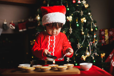 Girl preparing cookies on table during christmas