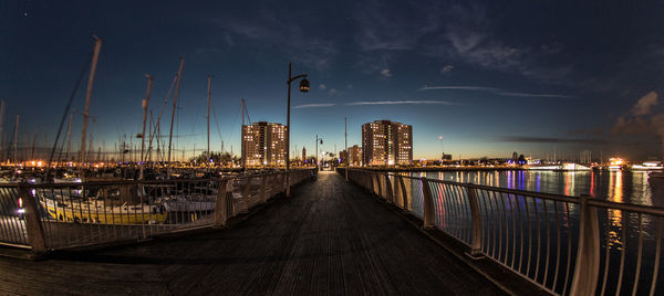 Panoramic view of harbor against sky at night