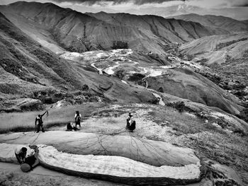 People with parachute on rocky mountain