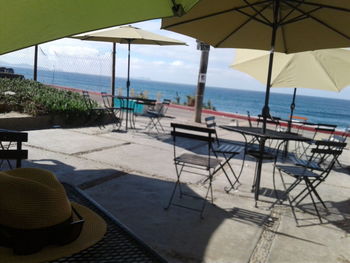 Empty chairs and table on beach