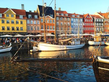Boats moored on river by buildings in city
