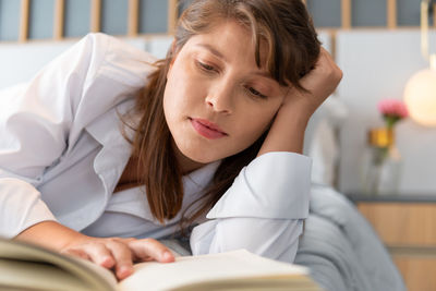 Portrait of young woman sitting on book