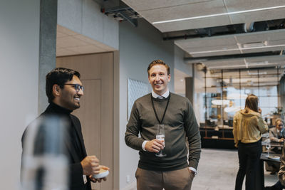 Smiling male delegates standing during networking conference