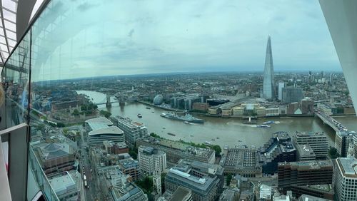 High angle view of city buildings against cloudy sky