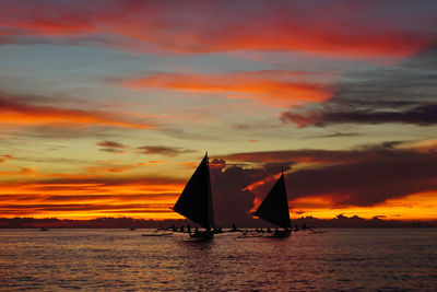Boat sailing in sea against sky during sunset
