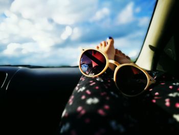 Close-up of sunglasses against sky