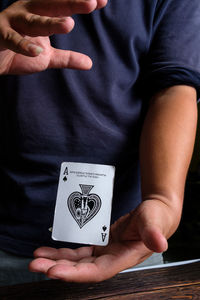 Midsection of man playing poker