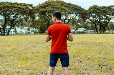 Rear view of boy standing on field