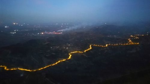 High angle view of illuminated cityscape against sky at night
