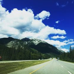 Surface level of country road against cloudy sky