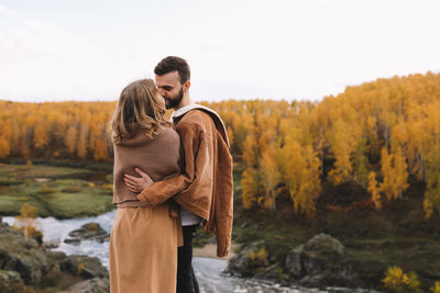 Happy people in love are travel hike in nature in the autumn forest. romantic trip to countryside