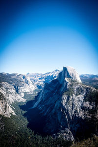 Scenic view of snowcapped mountains against clear blue sky