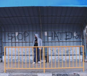 Rear view of man standing by railing in city