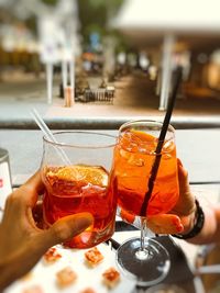 Close-up of hand holding drink on table at restaurant