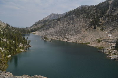 Scenic view of river by mountains against sky