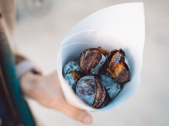 Cropped hand holding baked food in paper