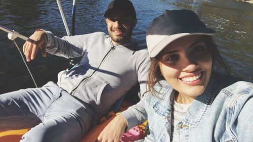 Portrait of smiling friends in boat on lake