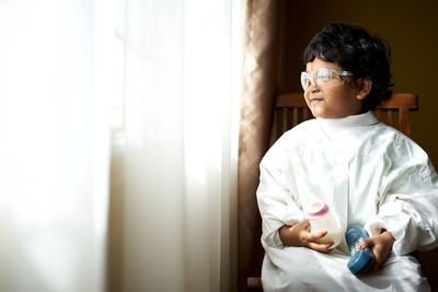 Boy looking away while sitting at home