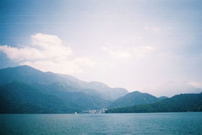 Scenic view of sea and mountains against sky