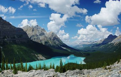 Scenic view of lake by mountains against cloudy sky