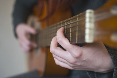 Midsection of woman playing guitar