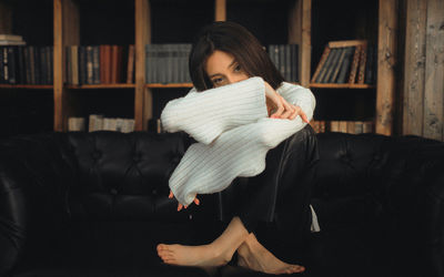 Side view of young woman sitting at home