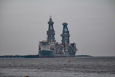 Commercial dock by sea against clear sky