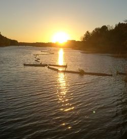 Silhouette boats in lake against sky during sunset