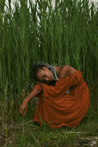 Portrait of young woman sitting on field