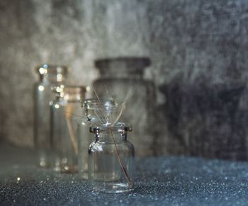 Close-up of wet glass on table against wall