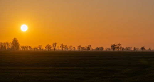 Scenic view of field against sky during sunset