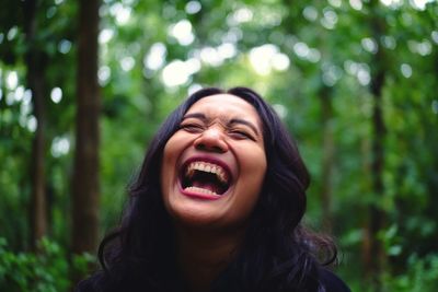 Close-up of happy woman in forest