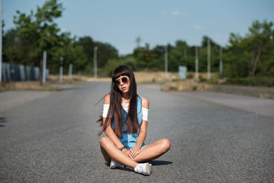 Portrait of beautiful young woman on road